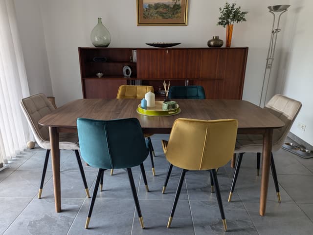 Une table et des chaises qui s'harmonisent parfaitement au meuble des années 50 au fond de la pièce.